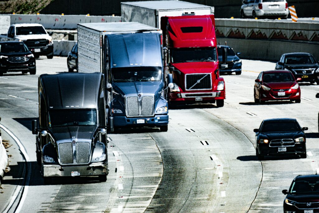 pexels photo 16325212 16325212 Trucks and cars traveling on a congested city highway during the day.